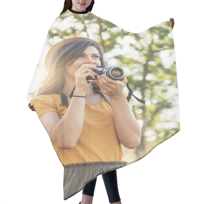 Personality  Smiling Young Woman Using A Camera To Take Photo At The Park. Hair Cutting Cape