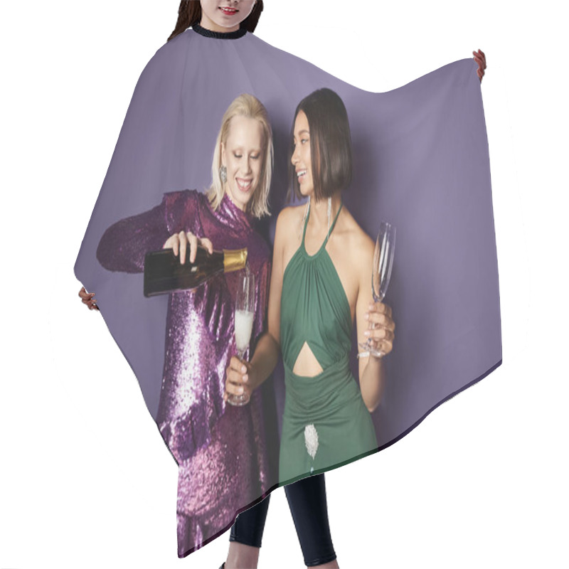 Personality  Joyful Blonde Woman Pouring Champagne Into Glass Of Asian Friend On Purple Backdrop, New Year 2024 Hair Cutting Cape