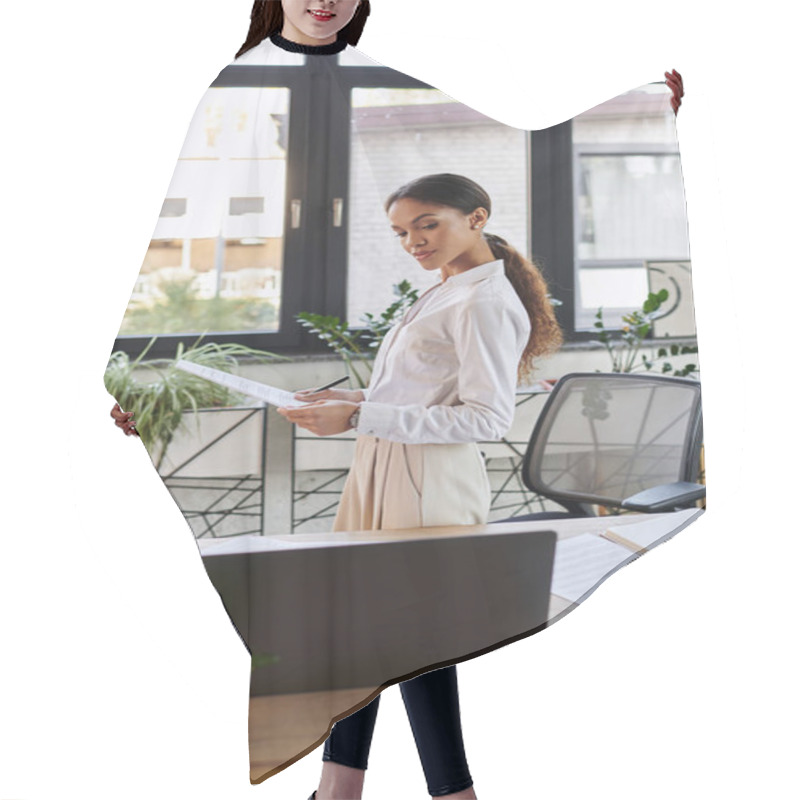 Personality  Young African American Woman In A White Shirt Reviews Documents While At Her Desk. Hair Cutting Cape