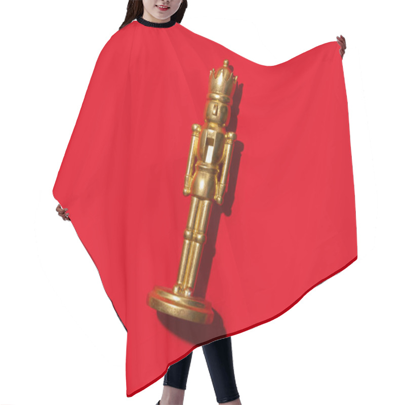 Personality  A Golden Nutcracker Figurine Standing Upright Against A Bold Red Background. This Minimalist And Vibrant Composition Emphasizes Holiday Cheer, Festive Tradition, And Timeless Decorative Elegance. Hair Cutting Cape