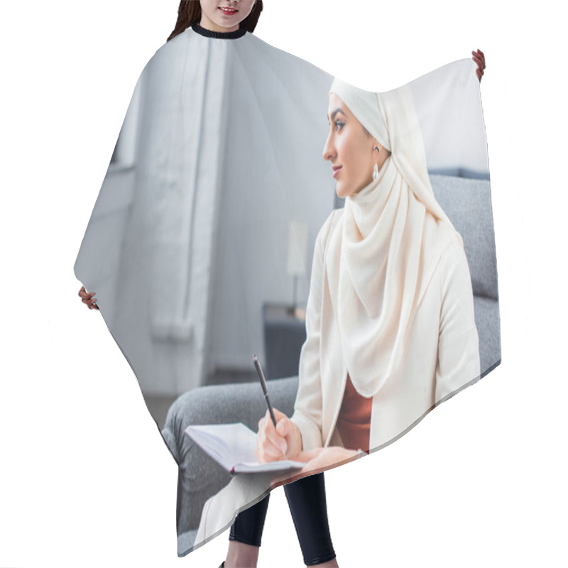 Personality  Beautiful Young Muslim Woman Sitting In Chair With Notepad And Looking Away Hair Cutting Cape