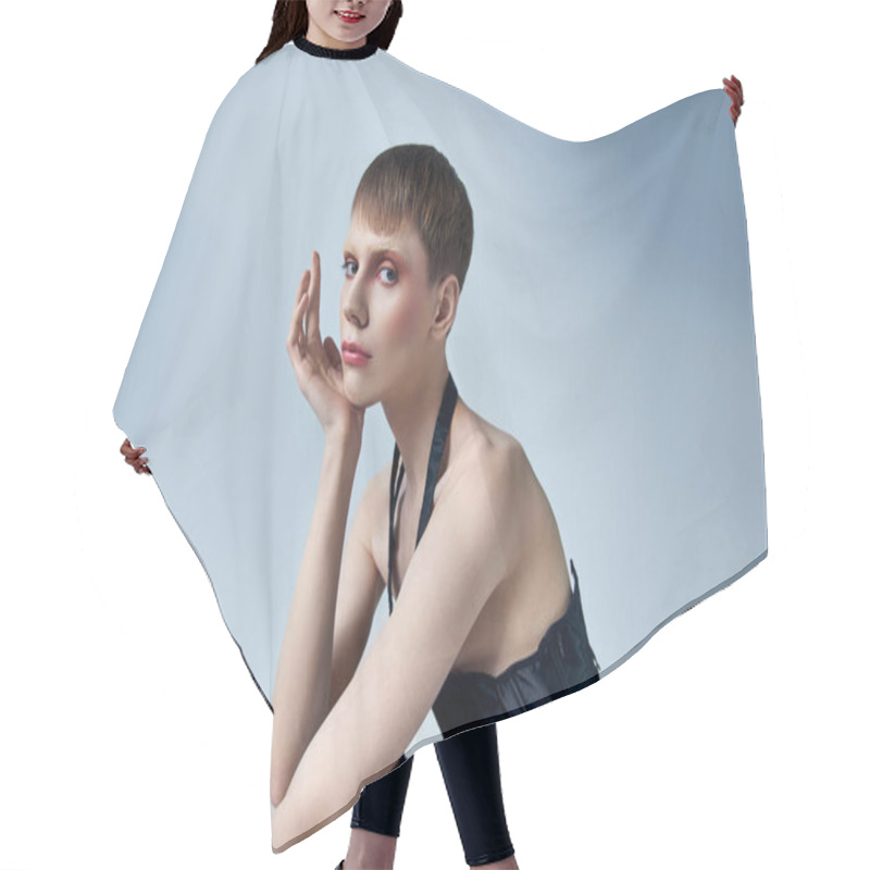 Personality  Model In Corset And Fishnet Tights Sitting On Grey Backdrop, Androgynous Person, Queer Fashion Hair Cutting Cape