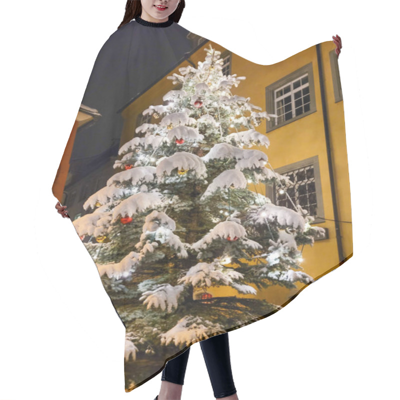 Personality  View Of The Christmas Tree In The Evening, Decorated With Lights, Christmas Balls And Covered With White Fluffy Snow. In The Background - Yellow And Red Buildings. Hair Cutting Cape