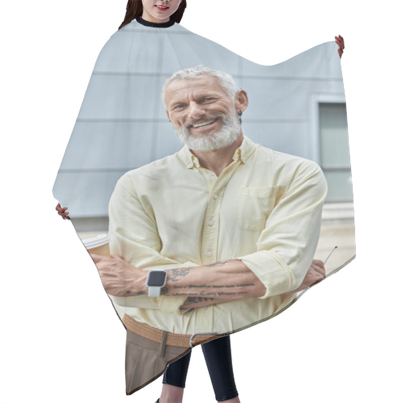 Personality  A Mature Man With A Beard And A Warm Smile Stands Outside, Holding A Coffee Cup. He Is Wearing A Light Yellow Shirt And Brown Pants. Hair Cutting Cape