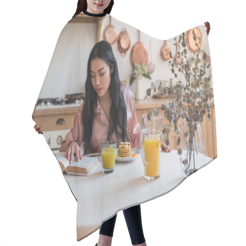 Personality  Young Asian Girl In Silk Pajamas Reading Book While Having Breakfast In Kitchen Hair Cutting Cape