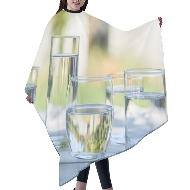 Personality  Clear Fresh Water In Transparent Glasses In Sunlight On Wooden Table Hair Cutting Cape