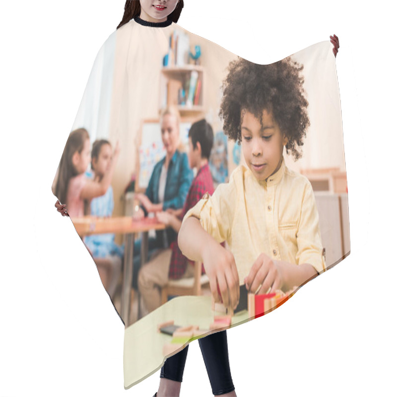 Personality  Selective Focus Of African American Kid Playing Educational Game With Teacher And Children At Background In Montessori School Hair Cutting Cape