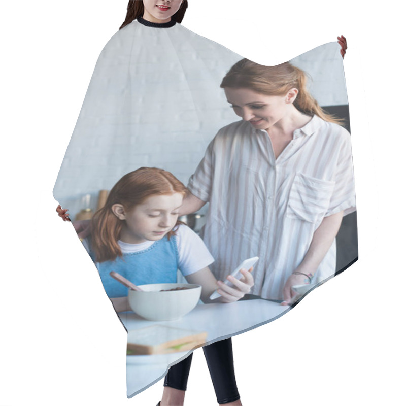 Personality  Happy Woman Looking At Daughter Using Smartphone During Breakfast Hair Cutting Cape