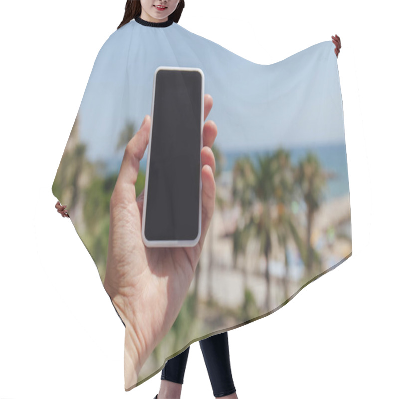 Personality  Cropped View Of Man Holding Smartphone With Palm Trees And Sea Coast At Background Hair Cutting Cape