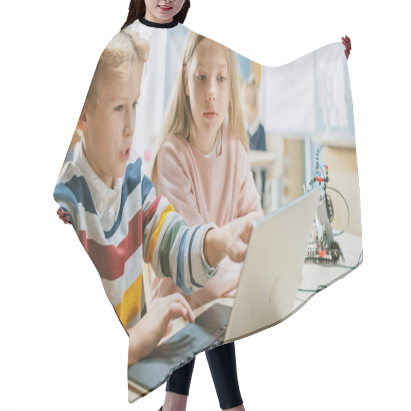 Personality  Brilliant Schoolgirl And Schoolboy Talk And Use Laptop To Program Software For Robotics Engineering Class. Elementary School Science Classroom With Children Working On Technology. STEM Education Hair Cutting Cape