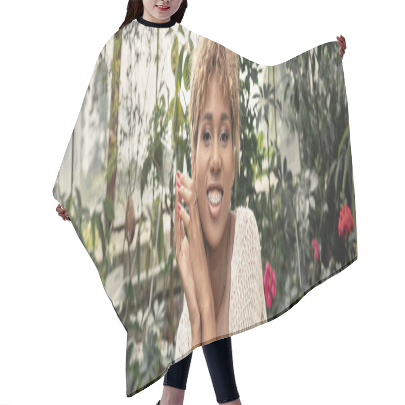 Personality  Cheerful Young African American Woman With Braces In Summer Knitted Top Looking At Camera While Spending Time In Blurred Orangey, Fashion-forward Lady In Midst Of Tropical Greenery, Banner  Hair Cutting Cape