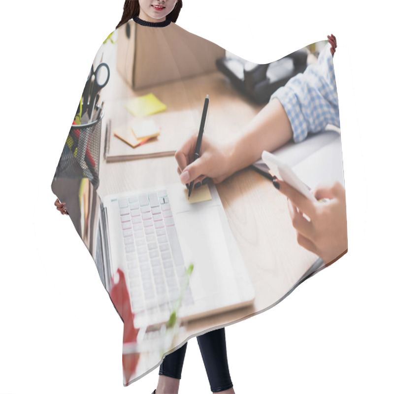 Personality  Cropped View Of Woman With Smartphone Writing On Sticker At Desk With Stationery And Devices On Blurred Foreground Hair Cutting Cape