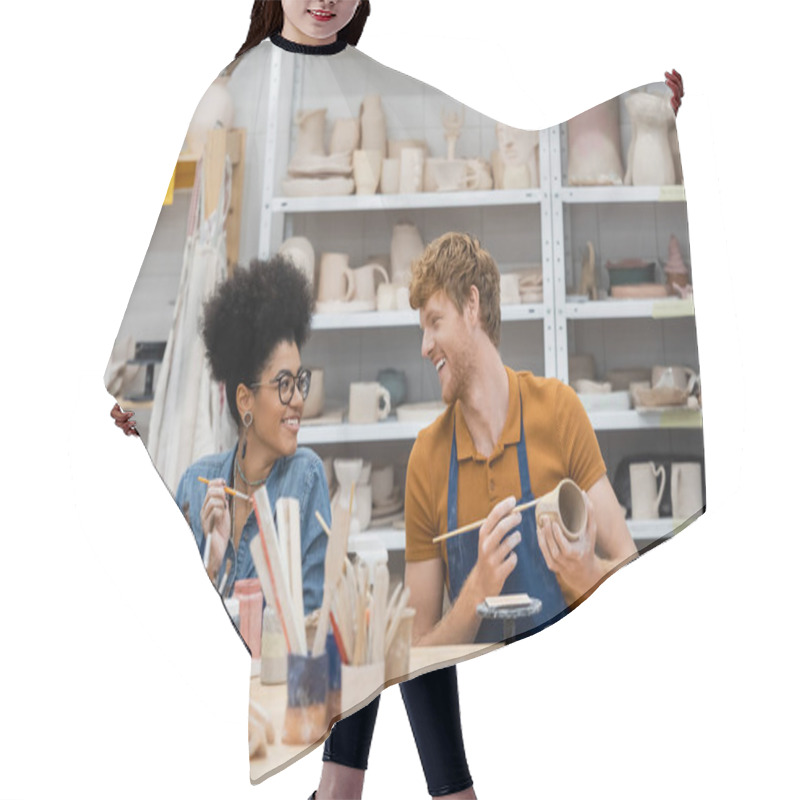 Personality  Smiling Man Looking At African American Girlfriend Near Clay And Paintbrushes In Pottery Studio  Hair Cutting Cape