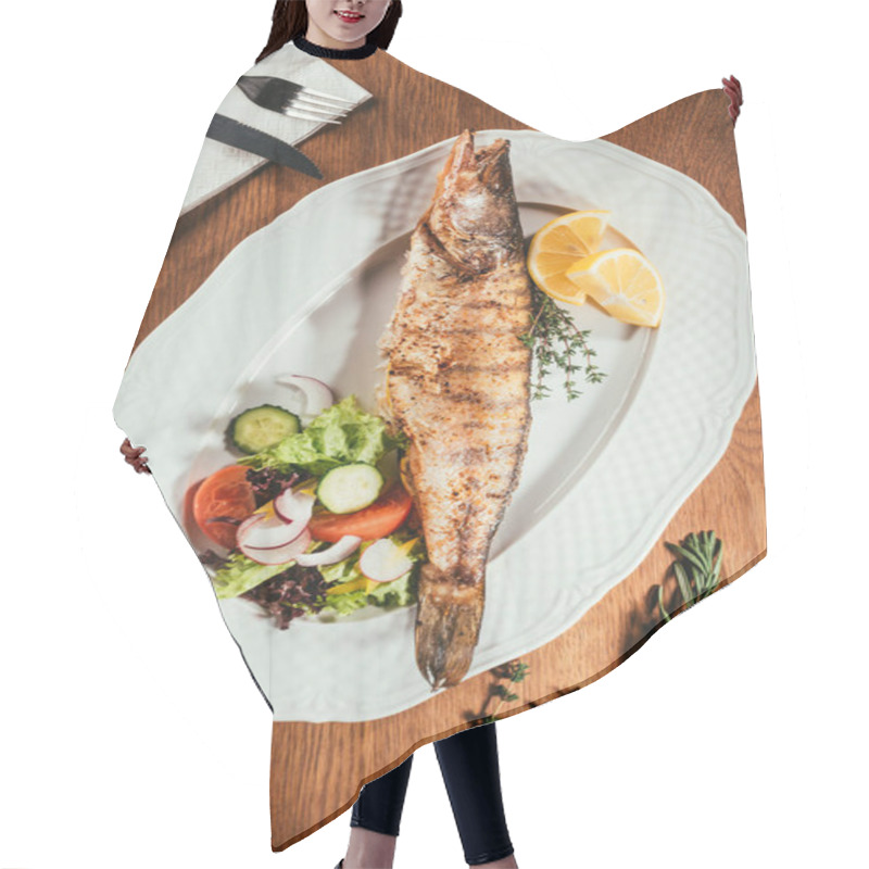 Personality  Fried Fish Laying On White Plate With Vegetables And Orange Slices Over Wooden Surface With Fork And Knife On Napkin Hair Cutting Cape