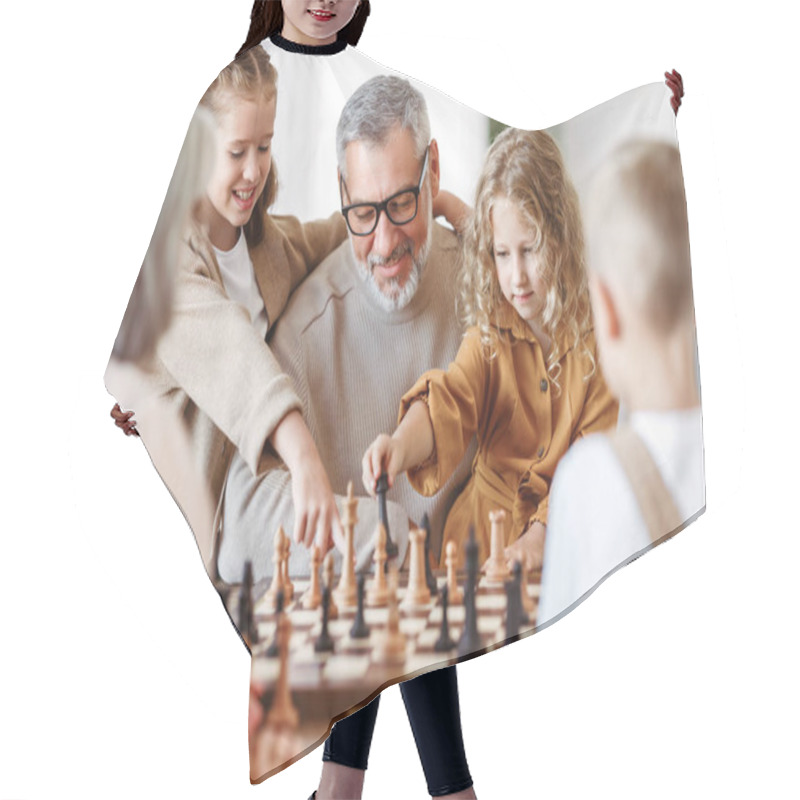 Personality  Joyful Children Brother And Sister Playing Chess While Sitting In Living Room With Senior Grandparents While Spending Time Together On Weekend, Kids Sitting At Table With Chessboard And Smiling Hair Cutting Cape