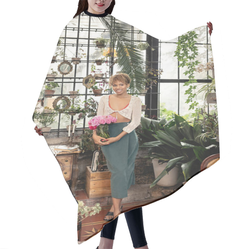 Personality  Full Length Of Stylish Young African American Woman In Summer Outfit Holding Vase With Pink Roses And Smiling While Standing In Modern Garden Center, Trendy Woman With Tropical Flair Hair Cutting Cape