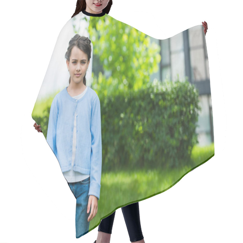 Personality  Serious Ukrainian Child In Blue Jumper And Jeans Looking At Camera On Blurred Background Hair Cutting Cape