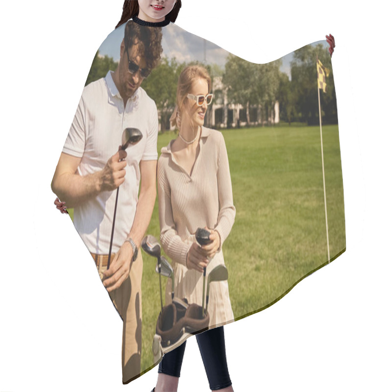 Personality  A Young Couple, Elegantly Dressed, Stands Together On A Picturesque Golf Course, Embodying A Classic, Upper-class Lifestyle. Hair Cutting Cape