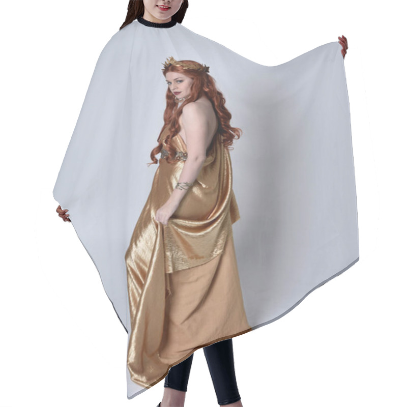 Personality  Full Length Portrait Of Girl With Red Hair Wearing Long Grecian Toga And Golden Wreath. Standing Pose With Back To The Camera,  Isolated Against A Grey Studio Background. Hair Cutting Cape