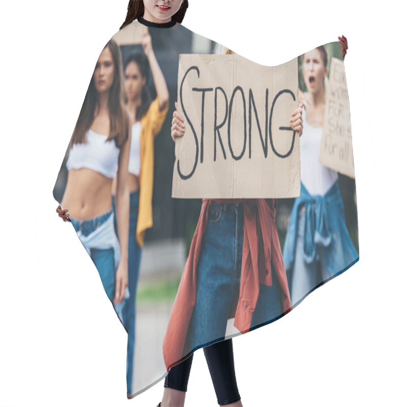 Personality  Cropped View Of Feminist Holding Placard With Inscription Strong Near Women On Street Hair Cutting Cape