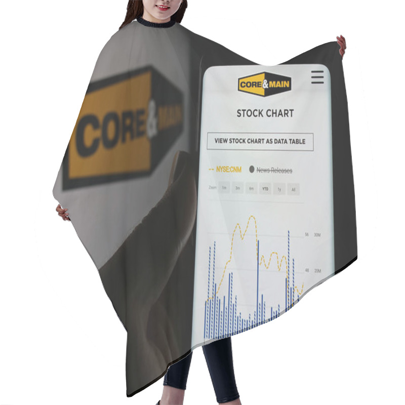 Personality  Stuttgart, Germany - 10-18-2024: Person Holding Cellphone With Webpage Of US Distribution Company Core Main Inc. On Screen In Front Of Logo. Focus On Center Of Phone Display. Hair Cutting Cape