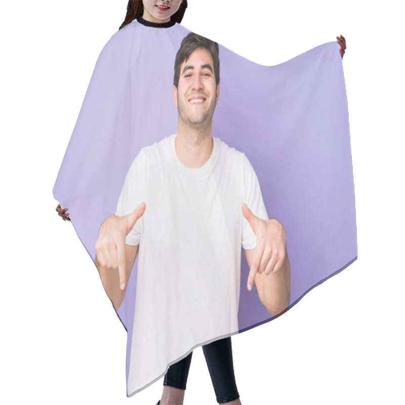 Personality  Young Man Isolated On Purple Background Points Down With Fingers, Positive Feeling. Hair Cutting Cape