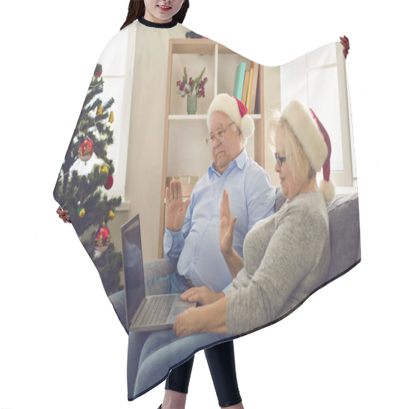 Personality  Side View Of Senior Couple In Christmas Hats Sitting On Sofa At Home And Waving In Front Of Webcam. Hair Cutting Cape