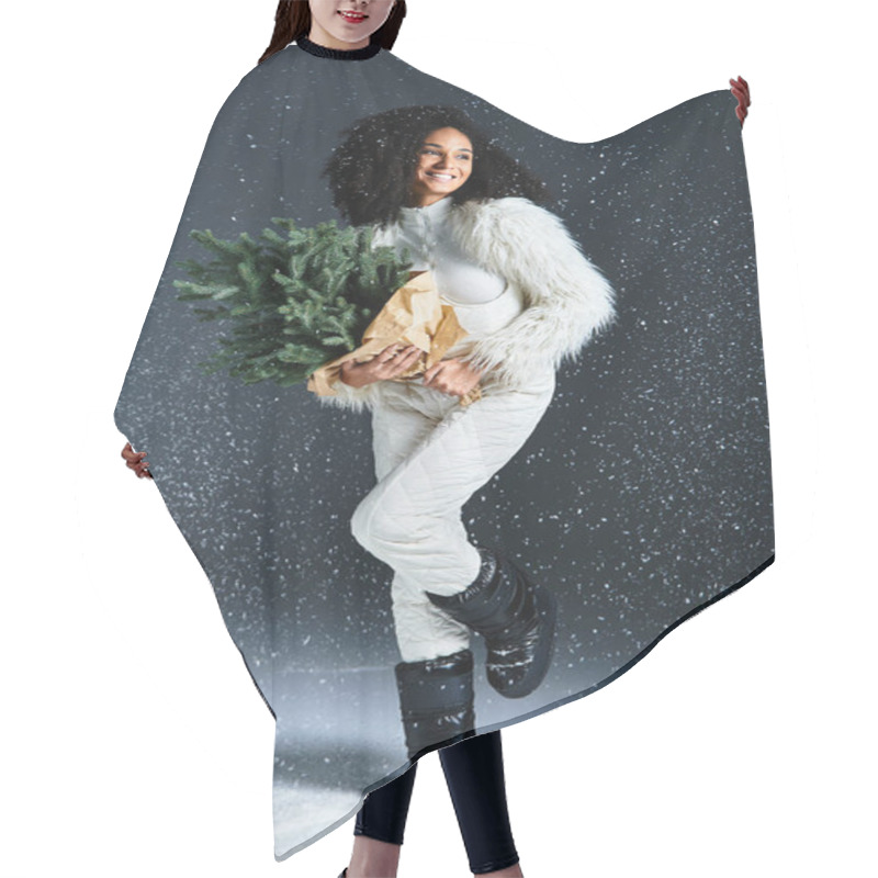 Personality  A Beautiful Woman Dressed In Winter Fashion Smiles While Holding A Small Holiday Tree, Surrounded By Falling Snow. Hair Cutting Cape