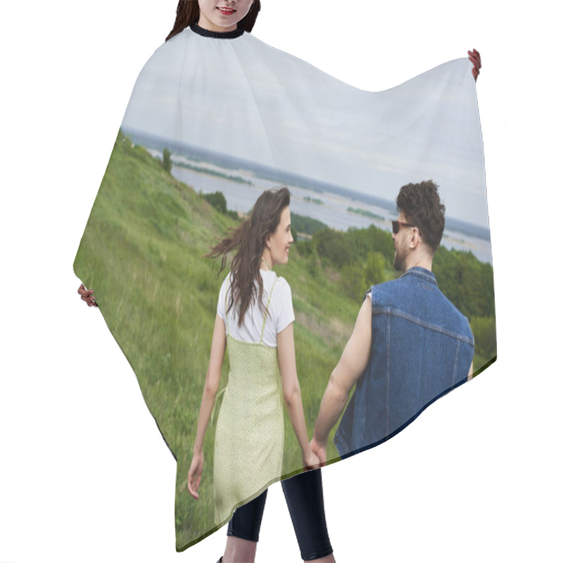 Personality  Side View Of Smiling And Trendy Romantic Couple In Summer Outfits Holding Hands While Walking On Grassy Hills With Cloudy Sky At Background, Couple In Love Enjoying Nature, Tranquility Hair Cutting Cape