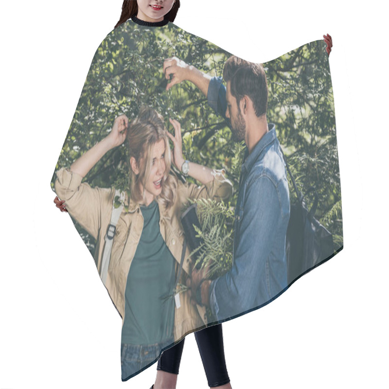 Personality  Young Man Helping Girlfriend To Get Out Of Tree Branches In Park Hair Cutting Cape