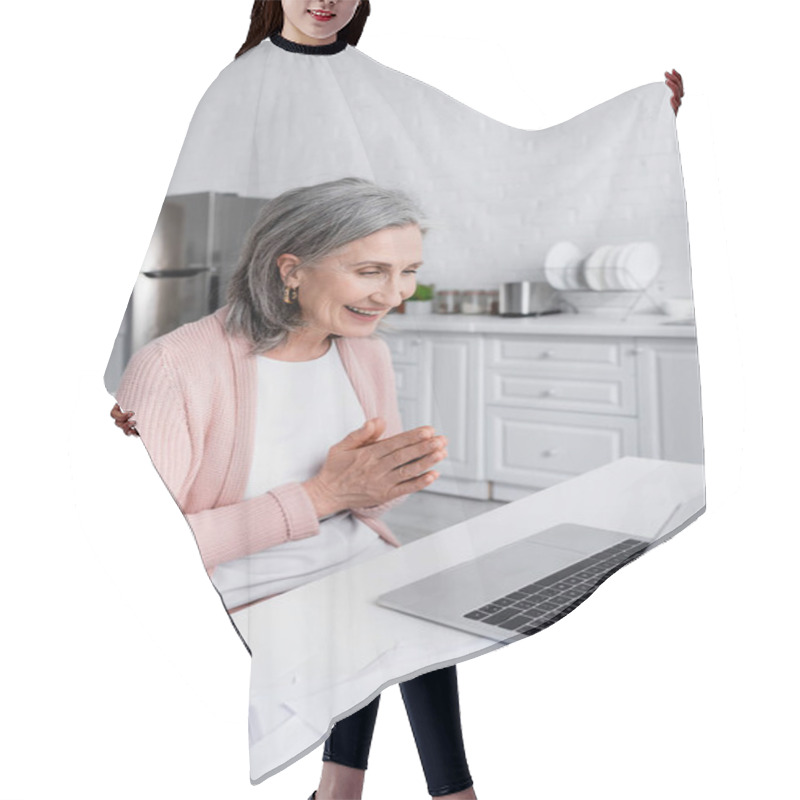 Personality  Grey Haired Woman Smiling And Doing Pray Gesture Near Devices And Bills In Kitchen  Hair Cutting Cape