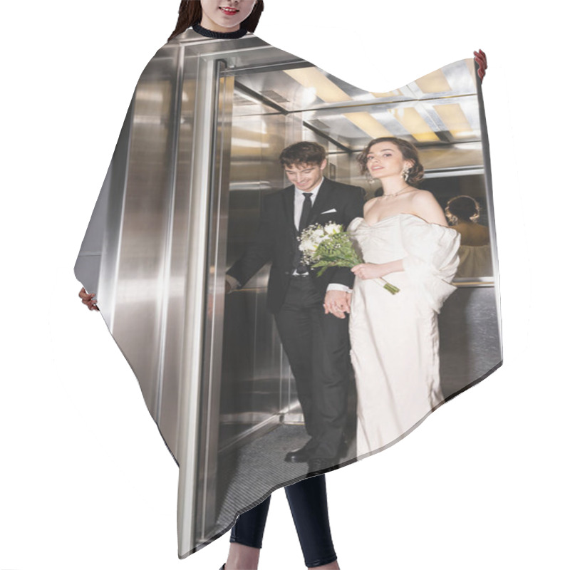 Personality  Full Length Of Pretty Bride In White Dress Holding Bridal Bouquet With Flowers And Hand Of Cheerful Groom In Suit Standing In Elevator In Hotel, Happy Newlyweds  Hair Cutting Cape