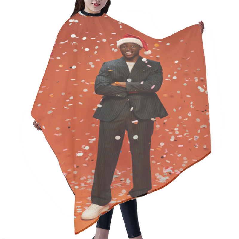 Personality  Excited African American Man In Black Suit And Santa Hat Smiling Under Confetti On Red Backdrop Hair Cutting Cape