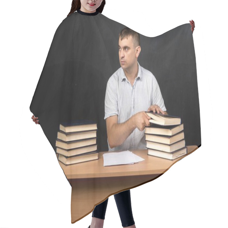 Personality  A Young Teacher Sitting At A Desk, Stacks Of Books On Either Side, And Papers In Front. Looking Away Thoughtfully, With A Black Background, Leaving Space For Text Or Design. Ideal For Educational Content Hair Cutting Cape