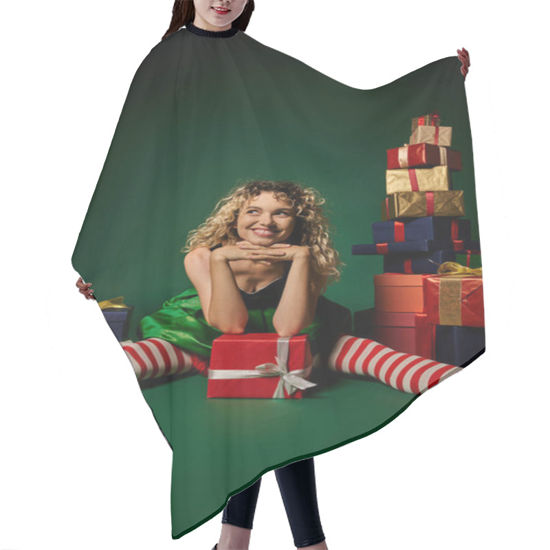 Personality  Jolly Woman In New Year Elf Costume Sitting On Floor Among Gifts With Hands Under Chin Looking Away Hair Cutting Cape