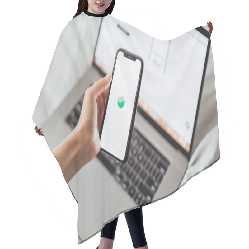 Personality   Hands Holding IPhone With Screen Of Sberbank Online App.  Hair Cutting Cape