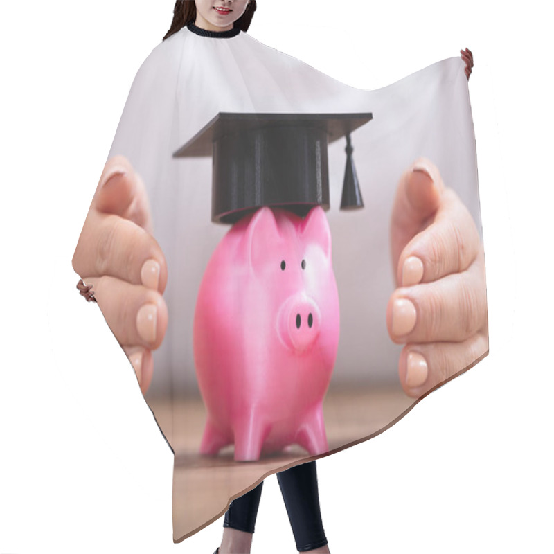 Personality  Close-up Of A Woman's Hand Protecting Piggy Bank With Graduation Cap On Wooden Desk Hair Cutting Cape