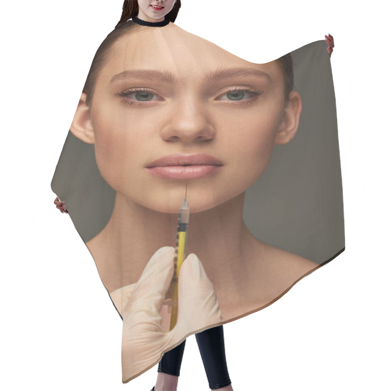 Personality  Esthetician In Medical Glove Holding Syringe Near Young Woman On Grey Background, Lip Filler Hair Cutting Cape