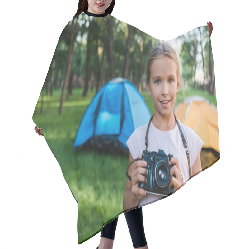 Personality  Smiling Child Holding Digital Camera Near Camps In Park  Hair Cutting Cape