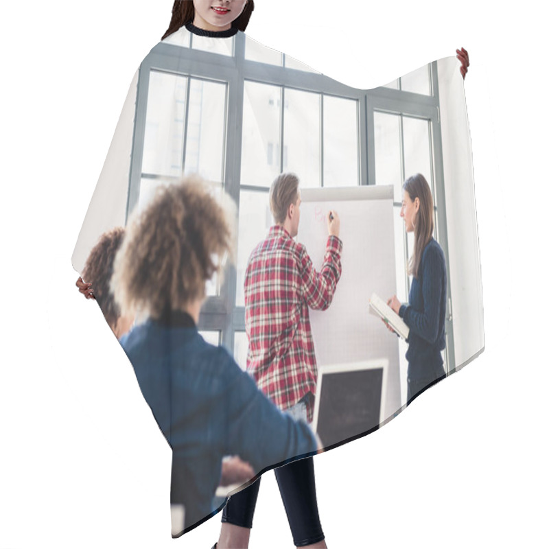 Personality  Student Writing On A Training Paper Board While Presenting With Hair Cutting Cape