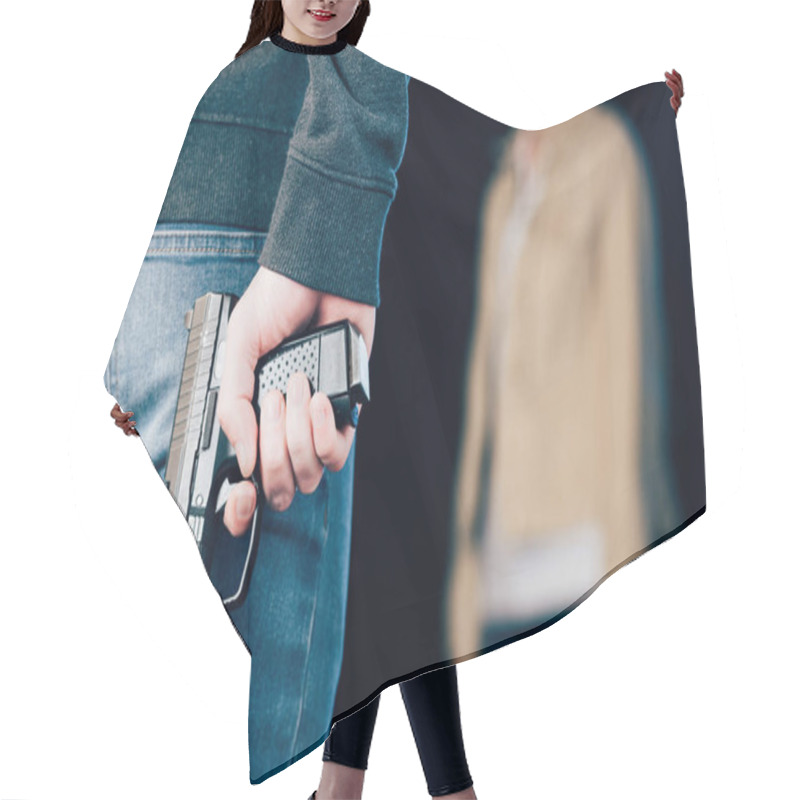 Personality  Cropped View Of Criminal Hiding Gun While Standing Near Woman On Black Hair Cutting Cape