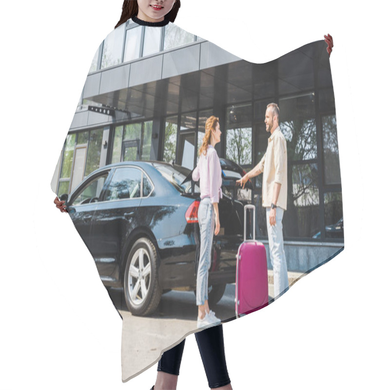 Personality  Cheerful Man Looking At Happy Woman While Standing Near Car And Pink Luggage  Hair Cutting Cape