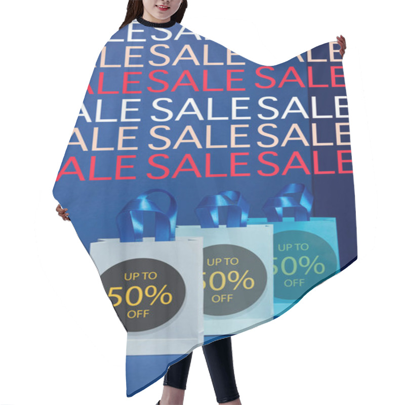 Personality  Close Up View Of Paper Shopping Bags Arranged On Blue Backdrop Sale Signs And 50 Percents Discount Hair Cutting Cape