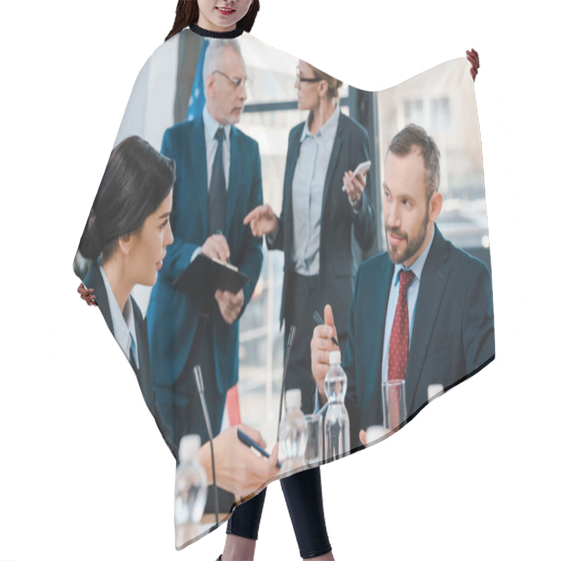 Personality  Selective Focus Of Diplomats Talking And Gesturing Near Glasses On Table  Hair Cutting Cape