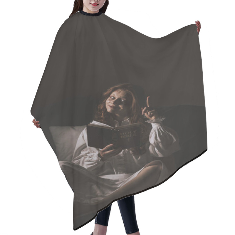 Personality  Demoniacal Girl In Nightgown Reading Bible And Pointing Up On Bed Hair Cutting Cape