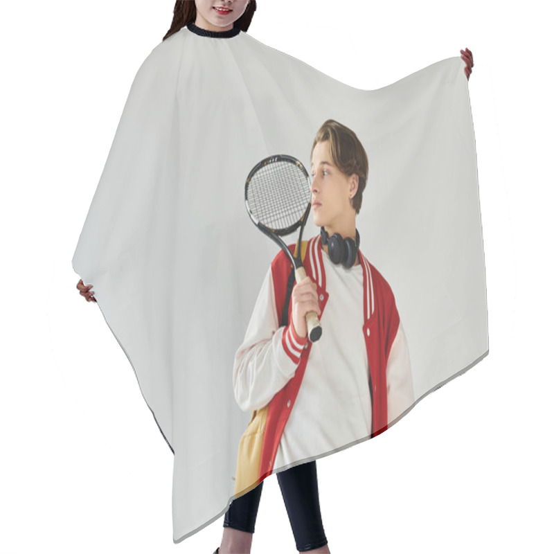 Personality  A Stylish Young Man Holds A Tennis Racket In A Studio, Exuding Confidence. Hair Cutting Cape