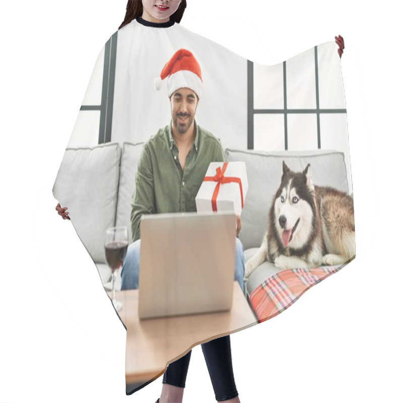 Personality  Young Hispanic Man Having Video Call Holding Gift And Sitting On Sofa With Dog At Home Hair Cutting Cape