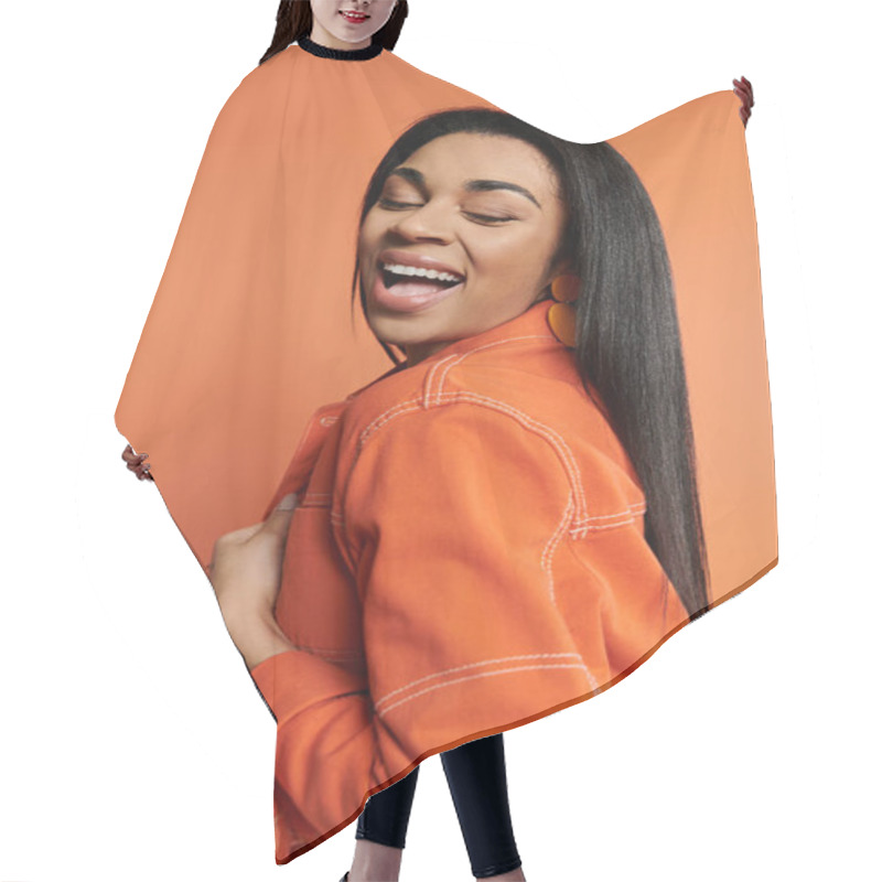 Personality  A Woman Radiates Happiness In A Striking Orange Outfit With A Warm Backdrop. Hair Cutting Cape