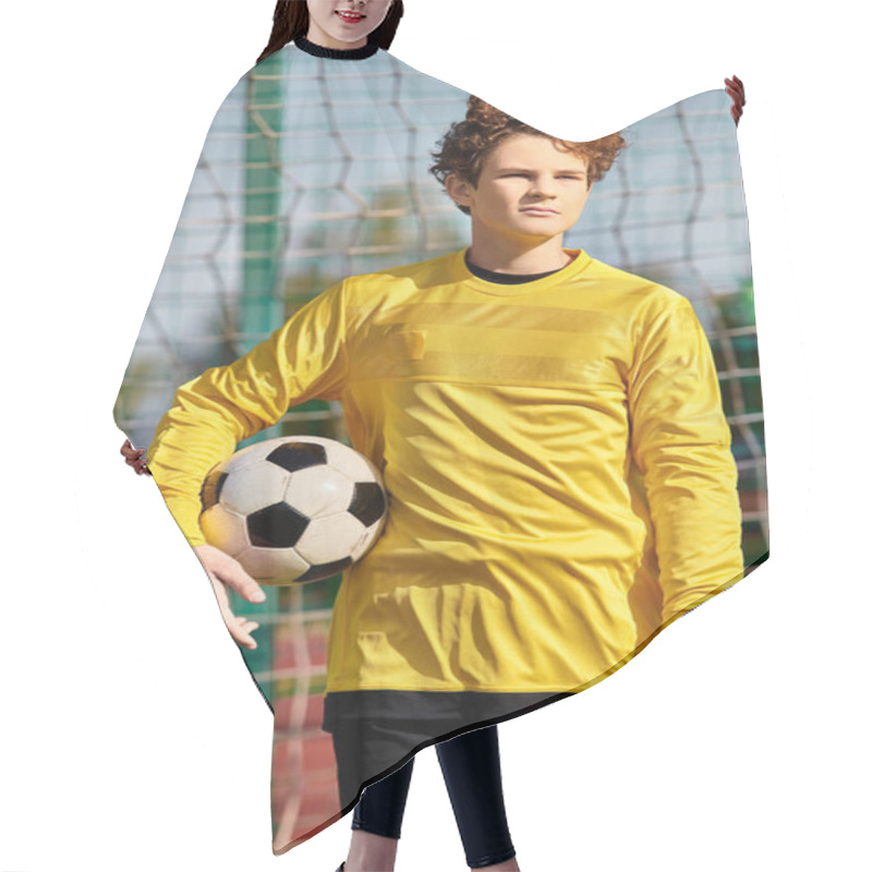 Personality  A Young Man Stands Confidently In Front Of A Soccer Net, Holding A Soccer Ball. He Gazes Ahead, Ready To Take On The Challenge Of Scoring A Goal. Hair Cutting Cape