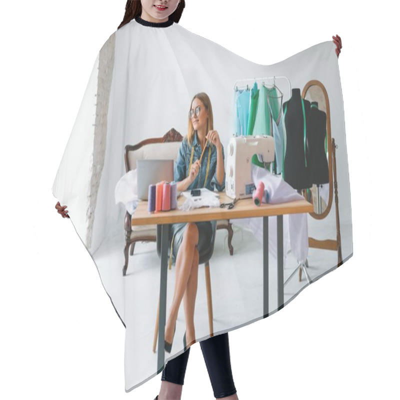 Personality  Smiling Fashion Designer Looking At Camera At Workplace, Dressmaker, Needlewoman Or Tailor Shop Owner Sitting At Desk With Color Swatches Pantone And Embroidery Design Sketches On The Wall, Portrait Hair Cutting Cape